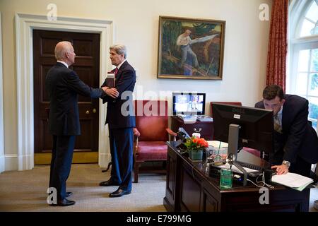 Vice Presidente USA Joe Biden colloqui con il Segretario di Stato John Kerry in esterno ufficio ovale come Brian Mosteller, Direttore dell Ufficio Ovale operazioni, lavora al computer nella Casa Bianca Giugno 12, 2014 a Washington, DC. Foto Stock