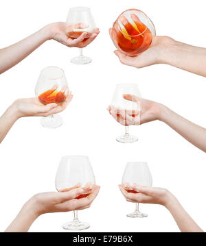 Set di mano trattiene calice di vetro con il cognac isolati su sfondo bianco Foto Stock