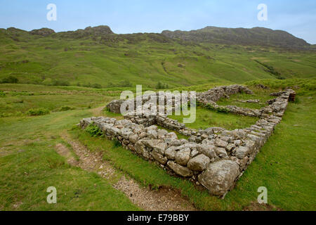 Estese rovine dell antica fortificazione romana a Hardknott Pass circondato dalle cime delle montagne e delle valli del Lake District inglese Foto Stock