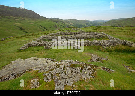 Estese rovine dell antica fortificazione romana a Hardknott Pass circondato dalle cime delle montagne e delle valli del Lake District inglese Foto Stock