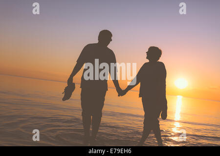 Felice coppia senior sagome sulla spiaggia Foto Stock