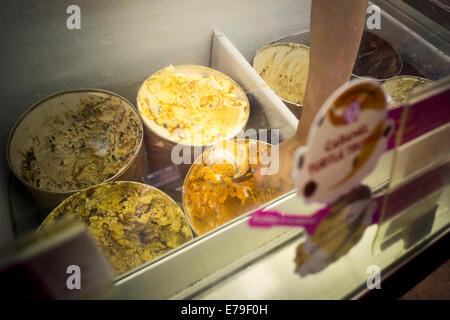 Un lavoratore scoop Cheesecake alla zucca gelato in un Baskin Robbins in New York Foto Stock