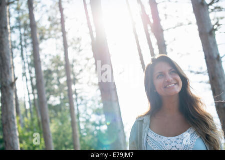 Una donna che gode di una piacevole passeggiata in una foresta. Foto Stock