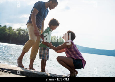 Una famiglia, genitori e figlio di un lago in estate. Foto Stock