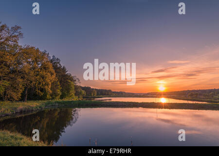 Bella estate tramonto sul lago vicino la foresta Foto Stock