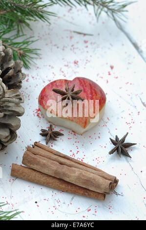 Pezzo di apple a forma di cuore e spezie nel decor di vacanza Foto Stock