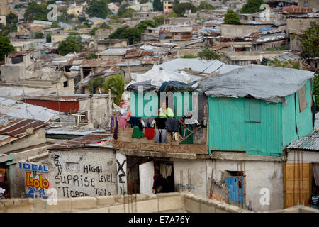 Donna sul balcone della sua verde-verniciato shack, Fort National baraccopoli, Port-au-Prince, Haiti Foto Stock