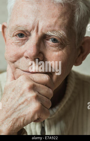 Close-up verticale di gravi senior con man mano sul mento Foto Stock