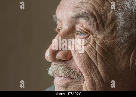 Grave senior l uomo che guarda lontano isolate su sfondo colorato Foto Stock