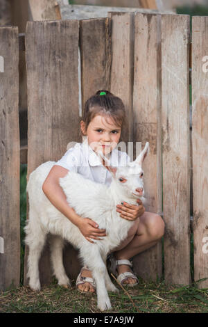 Ritratto di giovane ragazza con baby capra in posizione di parcheggio Foto Stock