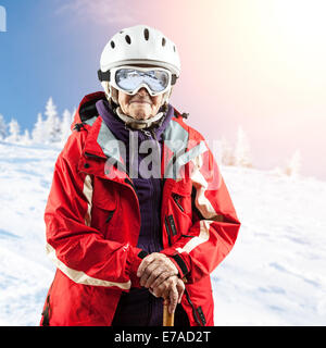 Senior donna in giacca da sci e occhiali all'esterno. Con il percorso. Foto Stock