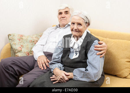 Uomo maturo e senior donna mentre è seduto sul divano Foto Stock