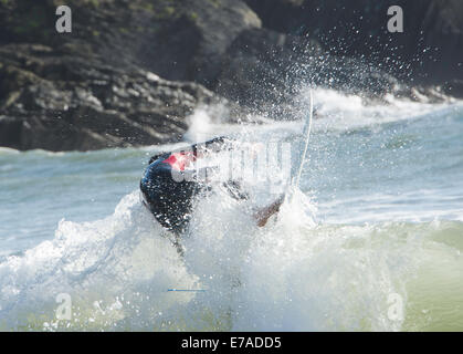 Azione girato di surfer wave riding con rocce in background Foto Stock