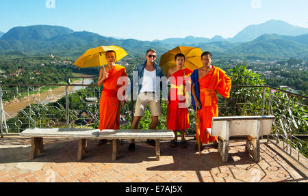 Traveler in posa con i monaci buddisti a un tempio in Luangprabang, Laos. Foto Stock