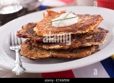 Una pila di deliziosa casa frittelle di patate con panna acida e erba cipollina. Foto Stock