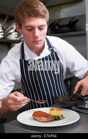 Lo Chef maschio preparazione di pasto in ristorante Cucina Foto Stock