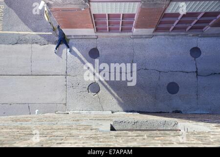 Una persona incosciente sdraiato a faccia in giù sul lato di un vicolo Foto Stock