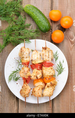 Pollo shish kebab e verdure fresche sulla tavola in legno rustico, vista dall'alto Foto Stock