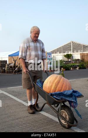 Harrogate, nello Yorkshire, Regno Unito. 11 Sett 2014. Andrew Jarrow wheeling sua zucca gigante atd Harrogate autunno annuale Flower Show, Yorkshire Showground, classificato come uno dei Gran Bretagna superiore tre eventi di giardinaggio. Nuovo per il 2014 è ispirazione Street, una serie di piccoli giardini sullo sfondo di un tradizionale scena di strada. Il viale si offrono una splendida scala maggiore sui giardini, più un nuovo spirito comunitario con la funzione 'messaggio in un giardino' disegni da gruppi di comunità e associazioni di beneficenza. Credito: Mar fotografico/Alamy Live News. Foto Stock