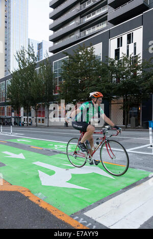 Seattle, Washington, Stati Uniti d'America. Undicesimo Sep, 2014. Uomo maturo segnala una svolta a destra dalla Seconda Avenue di Pike Street lungo la seconda Avenue protetti Pista Ciclabile progetto dimostrativo - Seattle, King County, Washington, Stati Uniti d'America. 8 settembre 2014 Seattle Dipartimento dei Trasporti ha aperto il protetto bike lane sulla Seconda Avenue tra Pike Street e Yesler modo. Il progetto include anche i segmenti di Pike Street tra la prima e la seconda avenue e sul modo Yesler tra Second Avenue e Occidental modo. Credito: Paolo Gordon/Alamy Live News Foto Stock