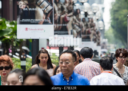 Pedoni attendere per attraversare la strada al di fuori del Takashimaya e Co. shopping mall in Orchard Road a Singapore Foto Stock