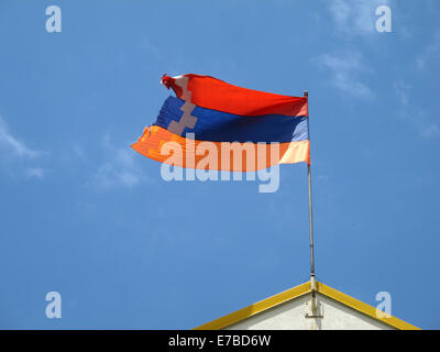 Stepanakert, Repubblica di Nagorno-Karabakh. Il 25 giugno, 2014. Bandiera della Repubblica di Nagorno-Karabakh vola su un edificio in Stepanakert, Repubblica di Nagorno-Karabakh, 25 giugno 2014. I colori della bandiera simboleggiano il collegamento con l' Armenia. La Repubblica di Nagorno-Karabakh è indipendente de facto ma non riconosciuto a livello internazionale stato contestato tra Armenia e Azerbaigian. La regione senza sbocchi sul mare nel Caucaso del Sud è abitata da armeni. Foto: Jens Kalaene - NESSUN SERVIZIO DI FILO-/dpa/Alamy Live News Foto Stock