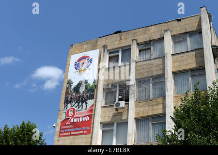 Stepanakert, Repubblica di Nagorno-Karabakh. Il 25 giugno, 2014. Un banner che mostra i soldati a parade pende da un edificio nel centro di Stepanakert, Repubblica di Nagorno-Karabakh, 25 giugno 2014. La Repubblica di Nagorno-Karabakh è indipendente de facto ma lo stato non riconosciuto disputata tra Armenia e Azerbaigian. La regione senza sbocchi sul mare nel Caucaso del Sud è abitata da armeni. Foto: Jens Kalaene - NESSUN SERVIZIO DI FILO-/dpa/Alamy Live News Foto Stock