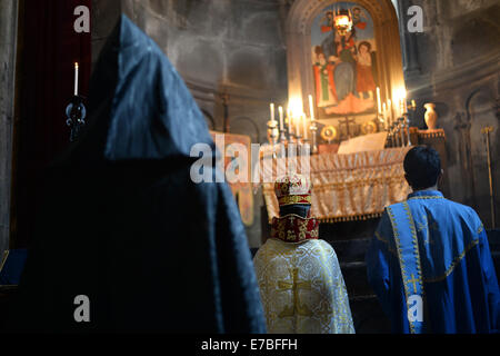 Un monaco, il pastore e un sagrestano indossare abito religioso durante il servizio di una Chiesa al Monastero di Geghard in Armenia il 29 giugno 2014. Il monastero è di particolare importanza per i credenti e i seguaci della Chiesa Apostolica Armena. L'Integrale nome del monastero, Geghardavank, significa "monastero della lancia' in riferimento al Santo la lancia che aveva ferito Gesù durante la crocifissione. Apostolo Taddeo si suppone di avere portato la lancia per l'Armenia. Esiste un partenariato UNESCO con abbazia di Lorsch in Hesse, Germania. Armeina è stato il primo paese a rendere il cristianesimo del suo stato religi Foto Stock