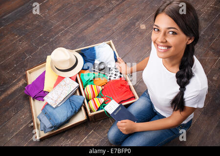 Felice di imballaggio ragazza la sua valigia Foto Stock