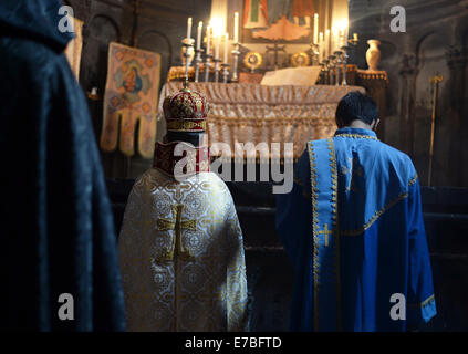 Un monaco, il pastore e un sagrestano indossare abito religioso durante il servizio di una Chiesa al Monastero di Geghard in Armenia il 29 giugno 2014. Il monastero è di particolare importanza per i credenti e i seguaci della Chiesa Apostolica Armena. L'Integrale nome del monastero, Geghardavank, significa "monastero della lancia' in riferimento al Santo la lancia che aveva ferito Gesù durante la crocifissione. Apostolo Taddeo si suppone di avere portato la lancia per l'Armenia. Esiste un partenariato UNESCO con abbazia di Lorsch in Hesse, Germania. Armeina è stato il primo paese a rendere il cristianesimo del suo stato religi Foto Stock