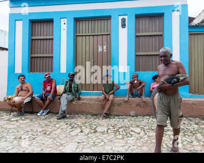 Uomo in strada a piedi con iguana, Trinidad, Cuba Foto Stock