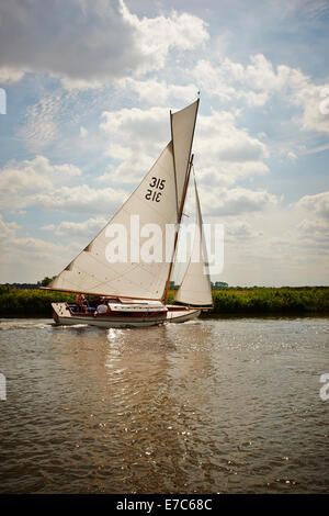 Classic Gaff truccate Norfolk Broads River cruiser yacht con veletta sul fiume Bure, Norfolk Broads, Norfolk, Inghilterra, Regno Unito. Foto Stock