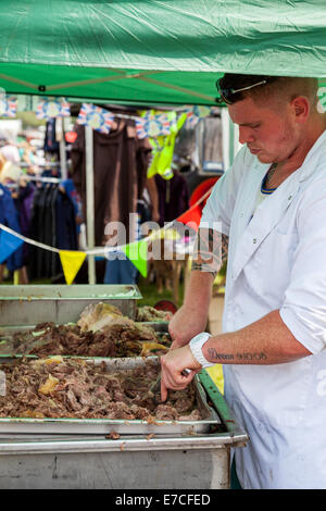 Il Porro & DISTRICT SHOW, Stoke On Trent Staffordshire Inghilterra giovane uomo caucasico carving arrosto di maiale fresche per il consumo pubblico Foto Stock