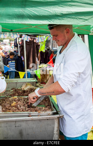 Il Porro & DISTRICT SHOW, Stoke On Trent Staffordshire Inghilterra giovane uomo caucasico carving arrosto di maiale fresche per il consumo pubblico Foto Stock