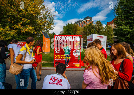 Mosca, Russia. Il 13 settembre 2014. Cosmopolitan la ben nota rivista femminile per la moda, bellezza, di relazioni e di stile di vita celebra 20 anni di presenza a Mosca nel parco Museon di arti. Le donne sono state incoraggiate a essere in rosso. Persone che hanno piacere e divertimento all'aria aperta. Fare una cover story. Finalmente soli. Credito: Alex Immagini/Alamy Live News Foto Stock