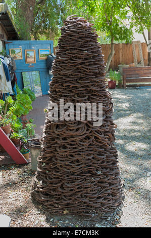 Vecchio & utilizzati Ferri da cavallo impilati come una moderna statua in una bottega artigiana di Los Alamos, California Foto Stock