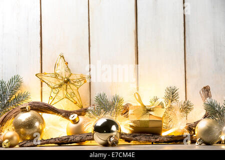 Le palle di Natale,ramo fir,candele accese e dono su asse di legno Foto Stock