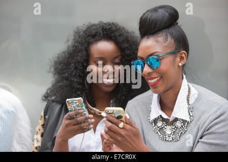 Londra, Regno Unito. Il 13 settembre 2014. Due le donne guardano a uno smartphone. Fashionistas di raccogliere al Somerset House alla settimana della moda di Londra. Foto: CatwalkFashion/Alamy Live News Foto Stock