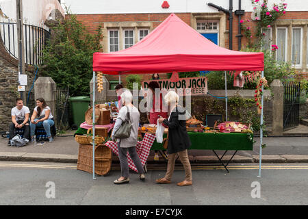 Ashburton Food & Drink Festival bancarelle del mercato UK. Dartmoor Jack bancarella vendendo una varietà di formaggi con due donne acquistare il formaggio. Foto Stock