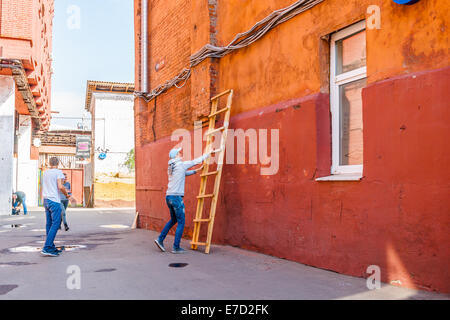 Mosca, Russia. Sabato 7 settembre 13, 2014. Street Art Festival Artside 2014 ha appena iniziato a Mosca. È stato deciso di vernice rosso opaco pareti di antichi edifici della ex fabbrica dolciaria ottobre rosso su Balchug isola del fiume di Mosca. La fabbrica spostato in un altro luogo, il vecchio sito industriale nel centro storico di Mosca è stato convertito in business e area ricreativa. Gli eventi del festival saranno in vigore durante tutto il mese di settembre 2014. Preparazione del luogo di lavoro. Credito: Alex Immagini/Alamy Live News Foto Stock