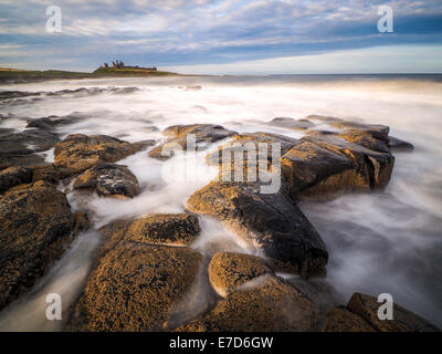 Incredibilmente aspra costa di Isola Santa in Northumberland è protetto da Lindisfarne Castle Foto Stock