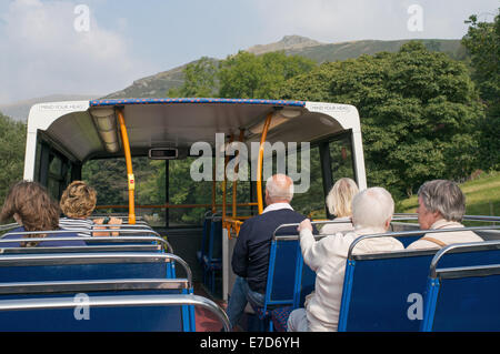 I passeggeri di equitazione a sommità aperta avvicinamento bus Grasmere da Rydal, Cumbria, England, Regno Unito Foto Stock
