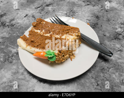 Un pezzo o fetta di torta di carote sulla piastra bianca con un nero forcella di plastica, Gateshead, Tyne and Wear, England, Regno Unito Foto Stock