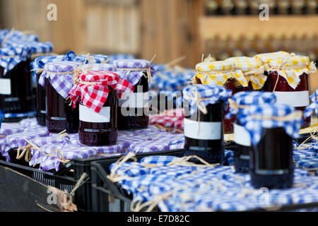 Molti barattoli per conserve con marmellata di scuro in un mercato all'aperto. Inquadratura orizzontale Foto Stock