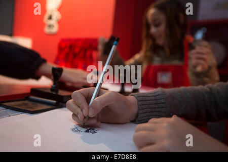 Buenos Aires, Argentina. Xiv Sep, 2014. Ragazze disegnare i personaggi dei cartoni animati di 'Mafalda' durante l'esposizione "Il mondo secondo Mafalda' a Usina arte nella città di Buenos Aires, Argentina, il 7 settembre 14, 2014. Il fumettista argentino e umorista Joaquin Salvador Lavado, meglio conosciuta come 'Quino', è il creatore del noto cartoon personalità 'Mafalda", una ragazza che percepisce la complessità del mondo attraverso la semplicità di un bambino agli occhi. Credito: Martin Zabala/Xinhua/Alamy Live News Foto Stock