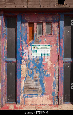 Una vecchia porta abbandonati con un segno parlando di un progetto di restauro di opere in downtown, Caledonia, Ontario, Canada. Foto Stock