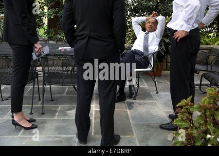 Il Presidente Usa Barack Obama parla con il capo del personale Denis McDonough, destra nazionale Consiglio Economico Vice Direttore Brian Deese e Katie Beirne Fallon, Direttore dell'Ufficio degli Affari Legislativi, sul patio al di fuori dell'Ufficio Ovale della Casa Bianca Luglio 18, 2014 a Washington, DC. Foto Stock