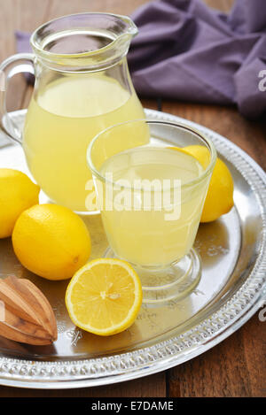 Il succo di limone fresco con limone e menta in vetro su sfondo di legno Foto Stock