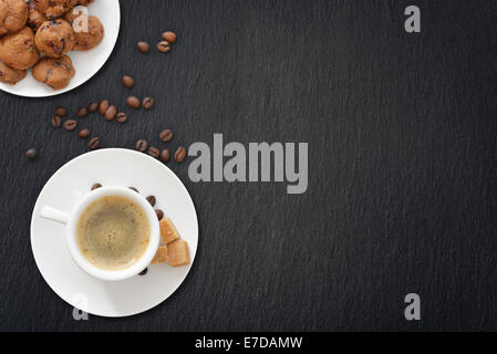 Tazza di caffè espresso e biscotti cookies su sfondo di ardesia. Vista dall'alto. Foto Stock