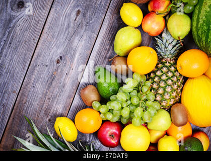 Un enorme gruppo di fresca frutta colorati su sfondo di legno - cibo sano Foto Stock